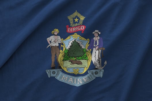 Maine US state flag depicted on folded wavy fabric of old cloth photo