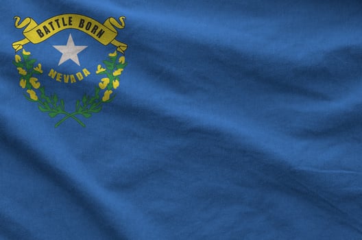 Nevada US state flag depicted on folded wavy fabric of old cloth photo