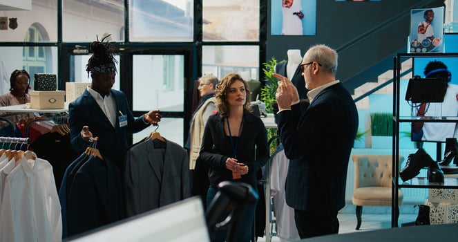 Famous fashion designer shopping for clothing items and accessories at store, explaining what luxury brands he wants for his new show. Senior couturier asking for certain materials. Camera B. photo