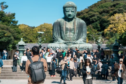 man tourist Visiting in Kamakura, Kanagawa, Japan. happy Traveler sightseeing the Great Buddha statue. Landmark and popular for tourists attraction near Tokyo. Travel and Vacation concept photo