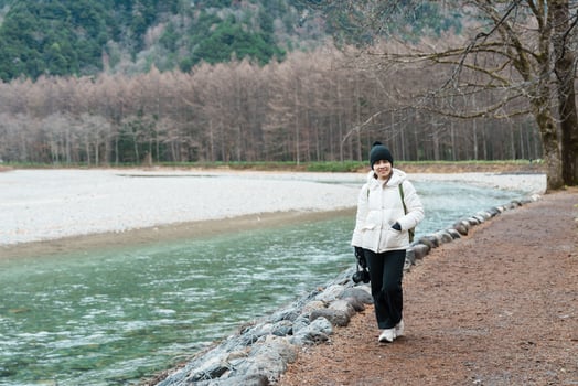 Woman tourist travel Kamikochi National Park, happy Traveler sightseeing Azusa river with mountain, Nagano Prefecture, Japan. Landmark for tourists attraction. Japan Travel, Destination and Vacation photo
