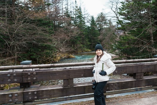 Woman tourist travel Kamikochi National Park, happy Traveler sightseeing Azusa river with mountain, Nagano Prefecture, Japan. Landmark for tourists attraction. Japan Travel, Destination and Vacation photo
