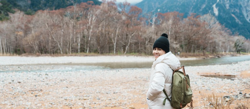 Woman tourist travel Kamikochi National Park, happy Traveler sightseeing Azusa river with mountain, Nagano Prefecture, Japan. Landmark for tourists attraction. Japan Travel, Destination and Vacation photo