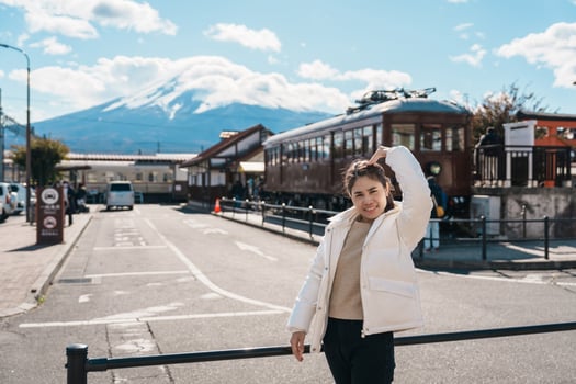 Woman tourist with Fuji Mountain at Kawaguchiko train station, happy Traveler sightseeing Mount Fuji in Yamanashi, Japan. Landmark for tourists attraction. Japan Travel, Destination and Vacation photo