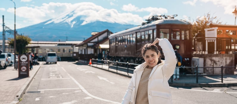 Woman tourist with Fuji Mountain at Kawaguchiko train station, happy Traveler sightseeing Mount Fuji in Yamanashi, Japan. Landmark for tourists attraction. Japan Travel, Destination and Vacation photo
