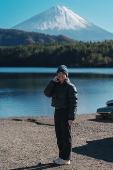 Woman tourist enjoy with Fuji Mountain at Lake Saiko, happy Traveler sightseeing Mount Fuji and road trip Fuji Five Lakes. Landmark for tourists attraction. Japan Travel, Destination and Vacation photo
