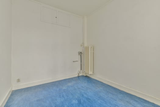 An empty room with a blue floor and white walls photo