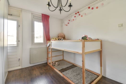 A small room with a bunk bed and a chandelier photo