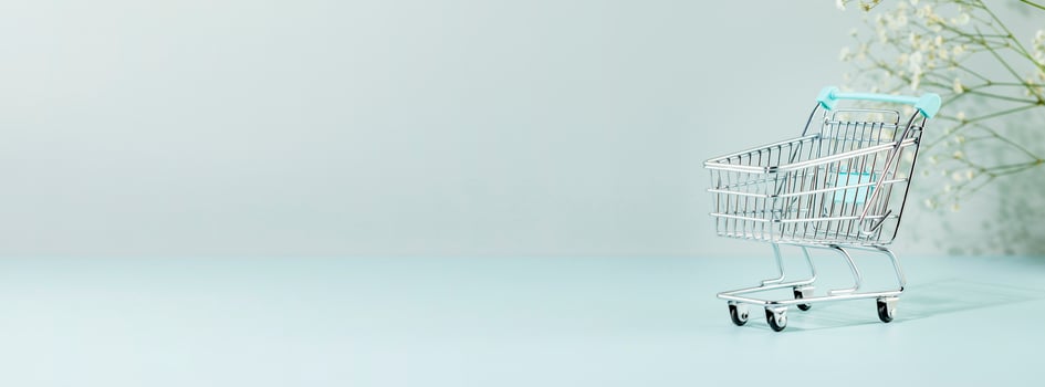 Shopping banner with rolley on blue background with white flowers photo
