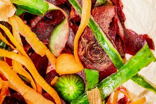Close up vegetable peelings on wrapping paper on white kitchen table photo
