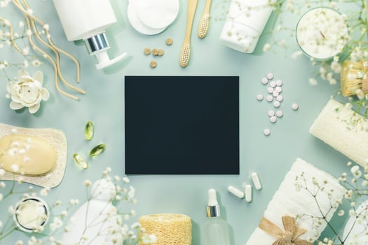 Beauty products on blue background with eempty chalkboard photo