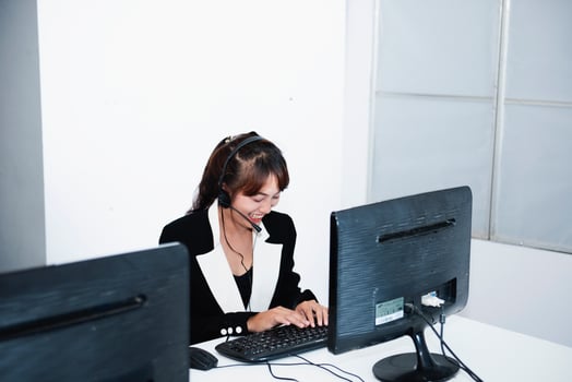 call center smiling business operator customer support team phone services agen working and talking with headset on desktop computer at call center photo