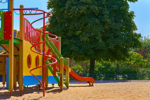 Summer children's playground with painted toy slide in public park photo