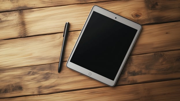 A sleek tablet rests on a wooden surface beside a stylish pen photo