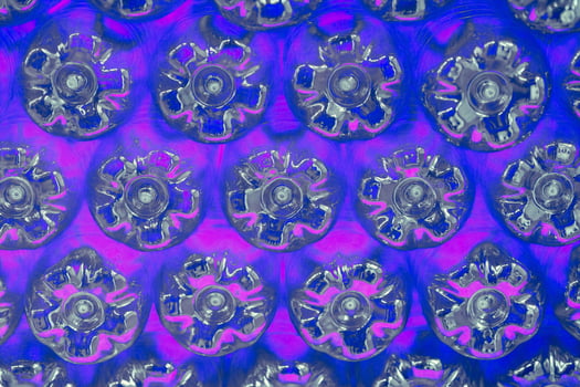 Abstract wall made from the bottoms of pink plastic bottles photo