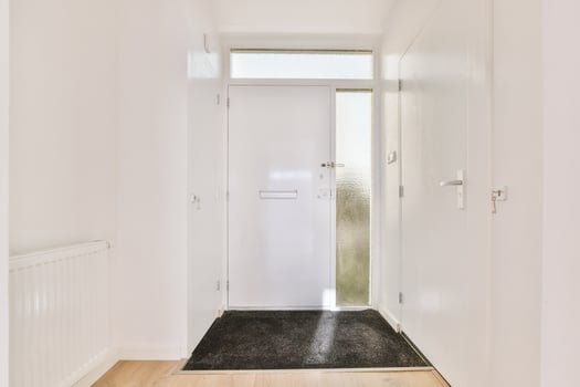A hallway with a door and a black rug photo