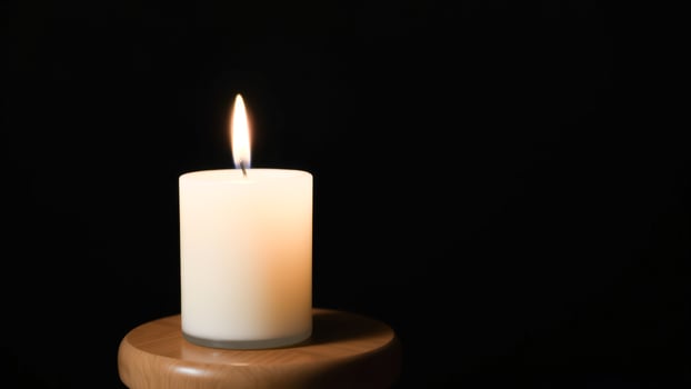 Single Burning Candle on Wooden Base photo