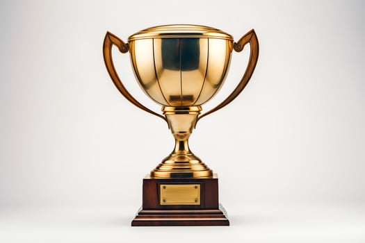 A gold trophy with a blank nameplate sits on a wooden base. The trophy is isolated on a white background. photo