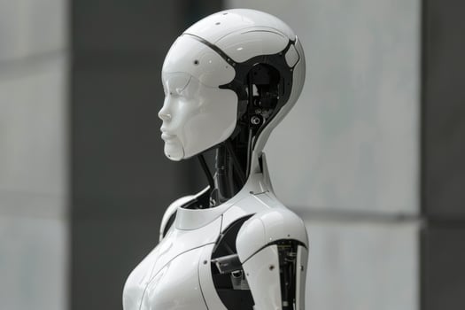 A white robot standing in front of a wall photo