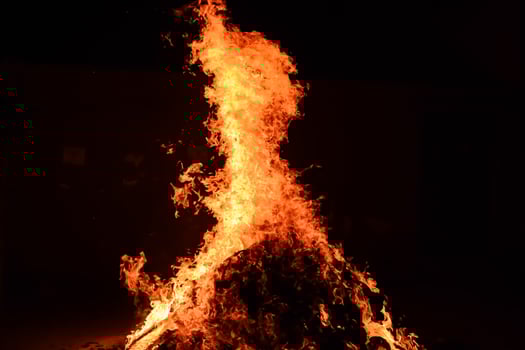 A bonfire is lit up in the dark photo