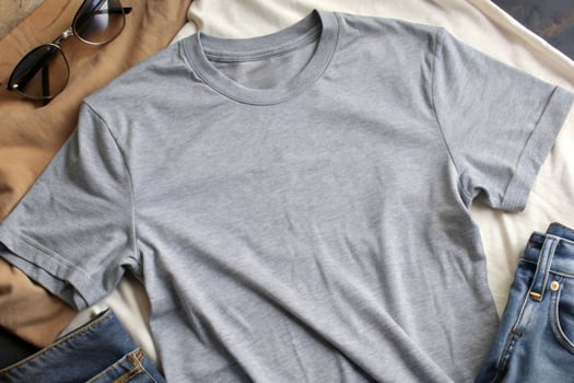 A gray t - shirt, jeans and sunglasses on a white background photo