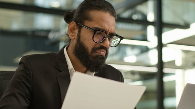 Arabian Muslim business man Indian businessman employer entrepreneur manager confused with papers and laptop in office problem paperwork bad result talking call working with documents failure photo