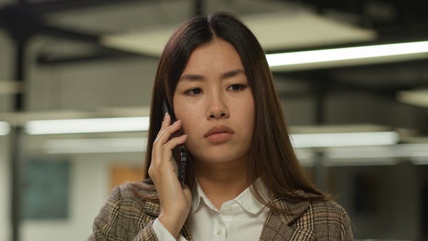 Asian girl student indoors listening bad news mobile phone call worry sad upset failure frustrated Korean business woman Japanese businesswoman Chinese female in office company talk smartphone problem photo