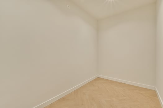 An empty room with white walls and wooden floors photo