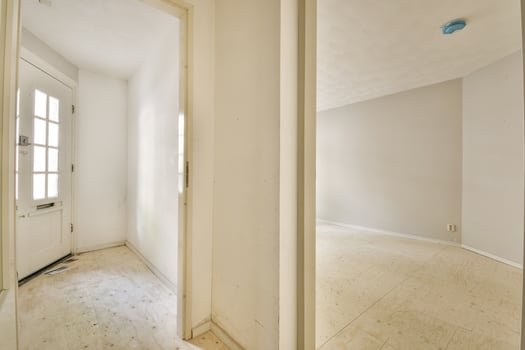 An empty room with a door and a white wall photo