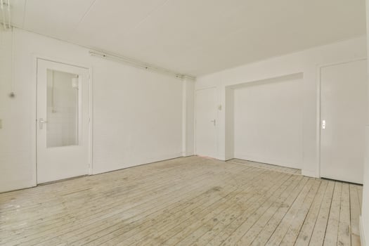 An empty room with white walls and wooden floors photo