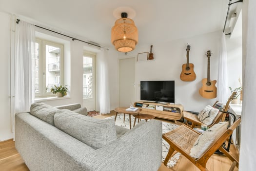 A living room with a couch, a guitar and a lamp photo