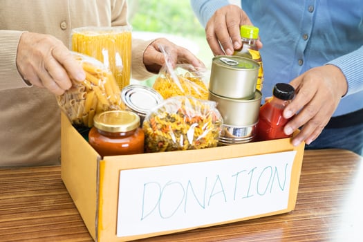 Volunteers putting various dry food in donation box for help people. photo