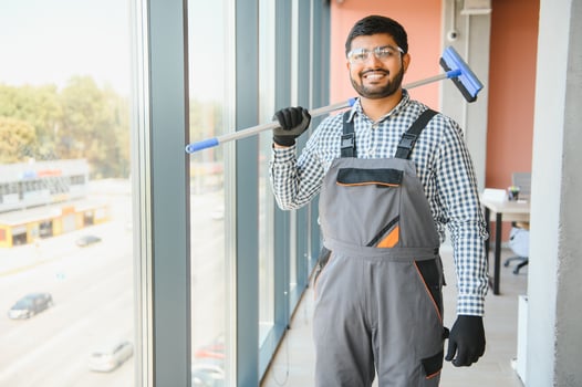 Cheerful male person cleaning window photo
