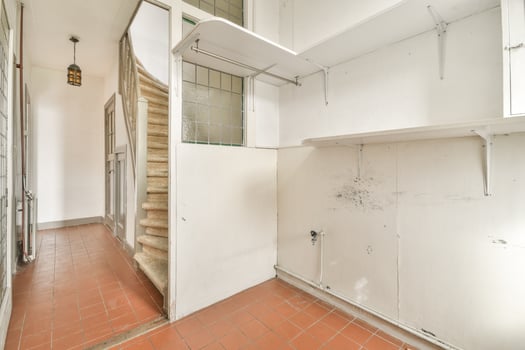 A hallway with a staircase and shelves in it photo
