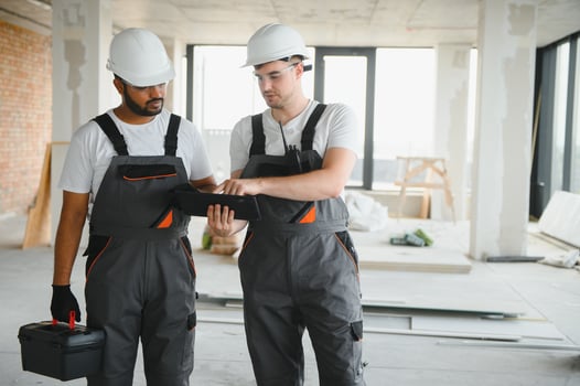 multicultural builders in hardhats at construction site photo