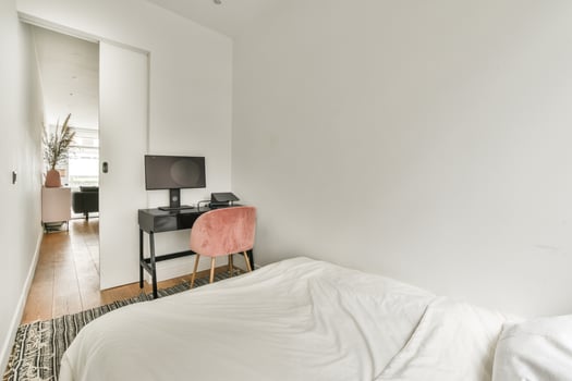 A bedroom with a desk and chair in it photo