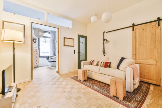 A living room with a couch, a television and a door photo