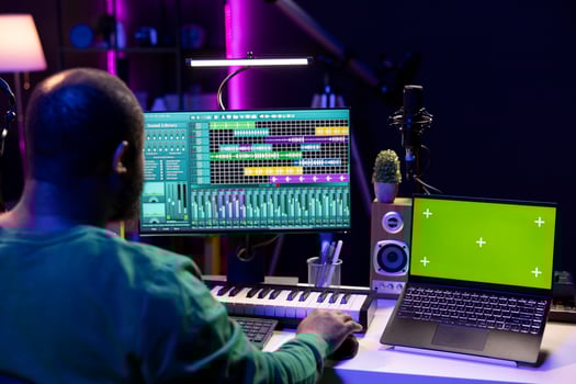 Music producer mixing and mastering songs on digital post production pc interface, greenscreen display. Artist adding sound effects and adjusting volume levels to produce new music. photo