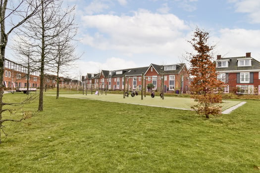A grassy area with trees and a building in the background photo
