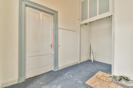 A room with a door and a blue carpet photo