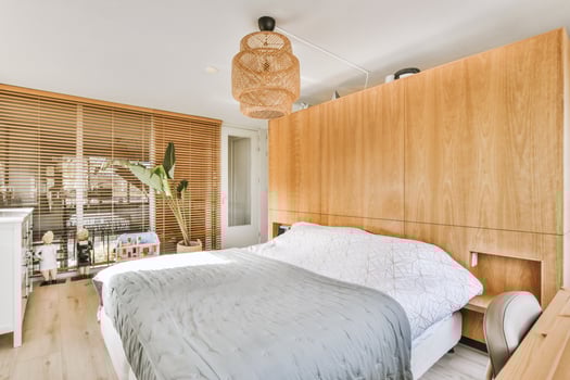 A bedroom with a bed, a desk, and a window photo