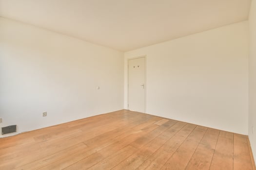 An empty room with hardwood floors and white walls photo