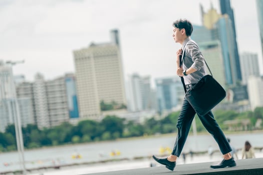 Asian businessman walking to work diligently and briskly in the morning in a big city. A man in a business suit, dressed in a smart suit, runs to work during rush hour in corridors and stairs. photo