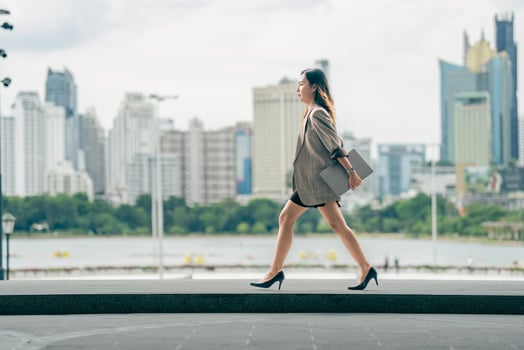 Asian business woman walking to work diligently and briskly in morning in a big city. female in a business suit, dressed in a smart suit, runs to work during rush hour in corridors and stairs. photo