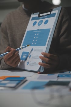 A man is holding a clipboard with a blue and white design on it photo