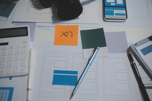 A desk with a calculator, pen, phone, and other items photo