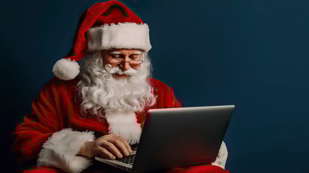 Santa Claus using a laptop on a blue background. Christmas and New Year. photo