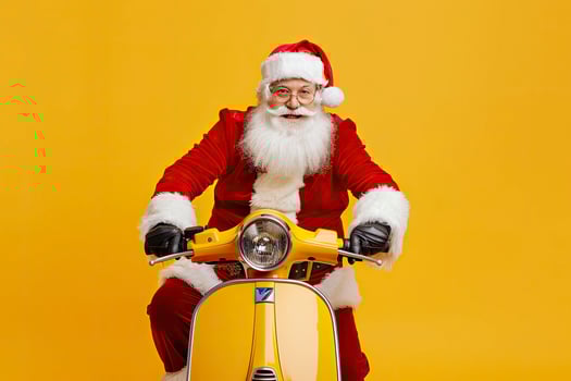 Santa Claus riding scooter isolated on yellow background. photo