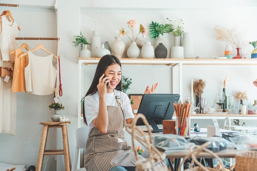 Small business owner talking on the phone with customers in a small shop. and check orders, check the orders that customers order from online retailers - online shopping photo