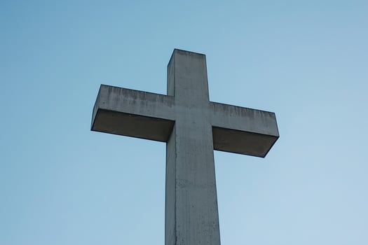 A Majestic Concrete Cross Set Against a Serene Sky photo